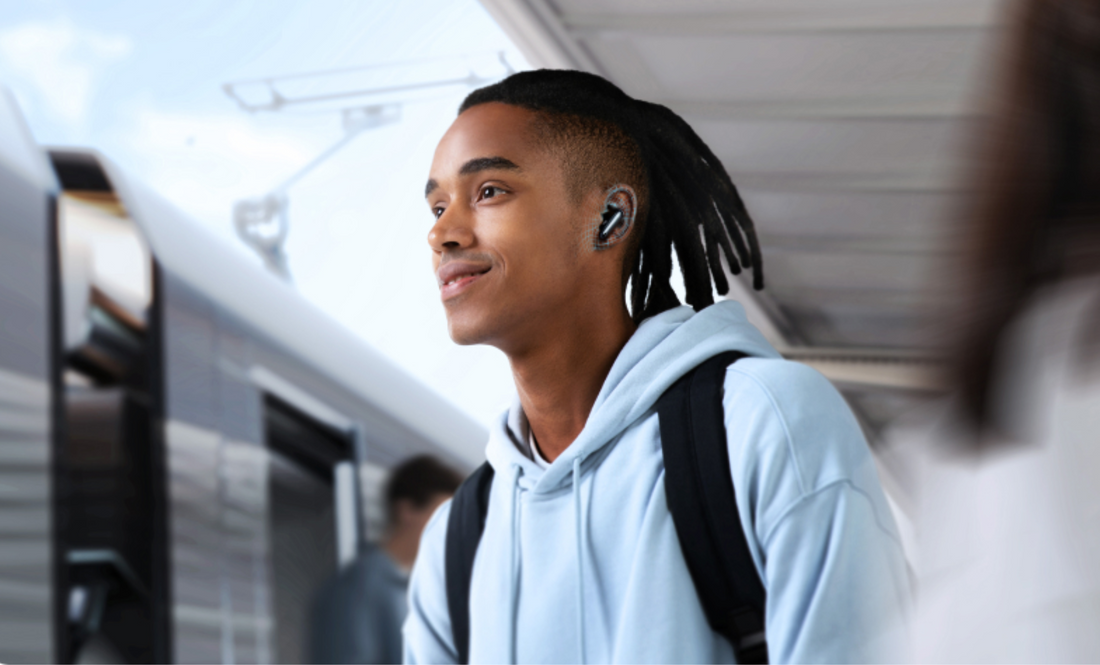Man som bär in-ear brusreducerande hörlurar under pendling