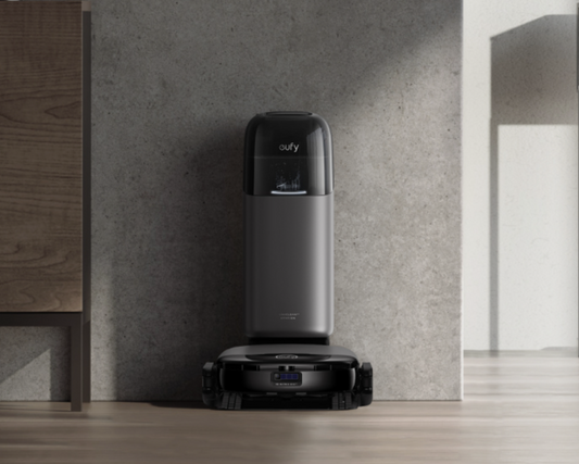 eufy Omni S1 Pro robotdammsugare med tömning i laddningsstation mot betongsvägg