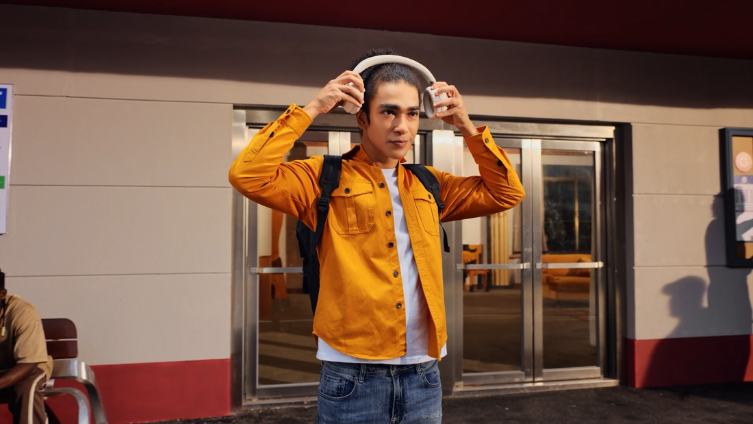Man sätter på sig soundcore Space One Pro noise cancelling hörlurar utomhus